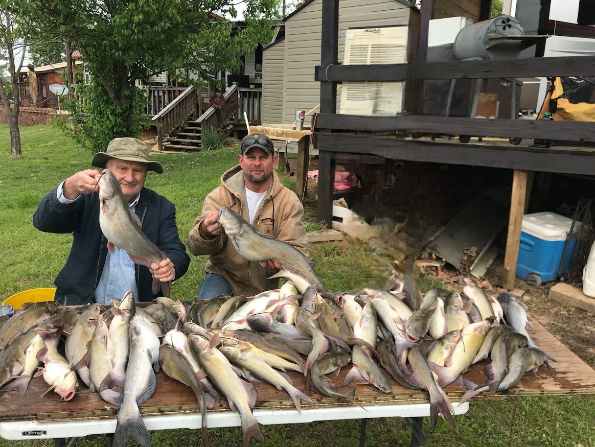 Two men with a massive table full of catfish after a jugline trip