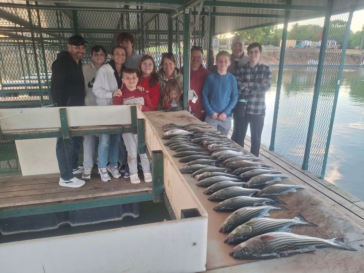 Big family group with a huge catch of stripers at the covered dock